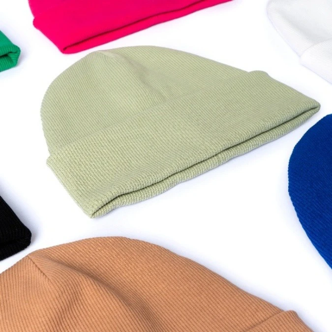 Branded corporate beanies neatly laid out side by side on a flat surface, showcasing customisable headwear options for team or promotional use.